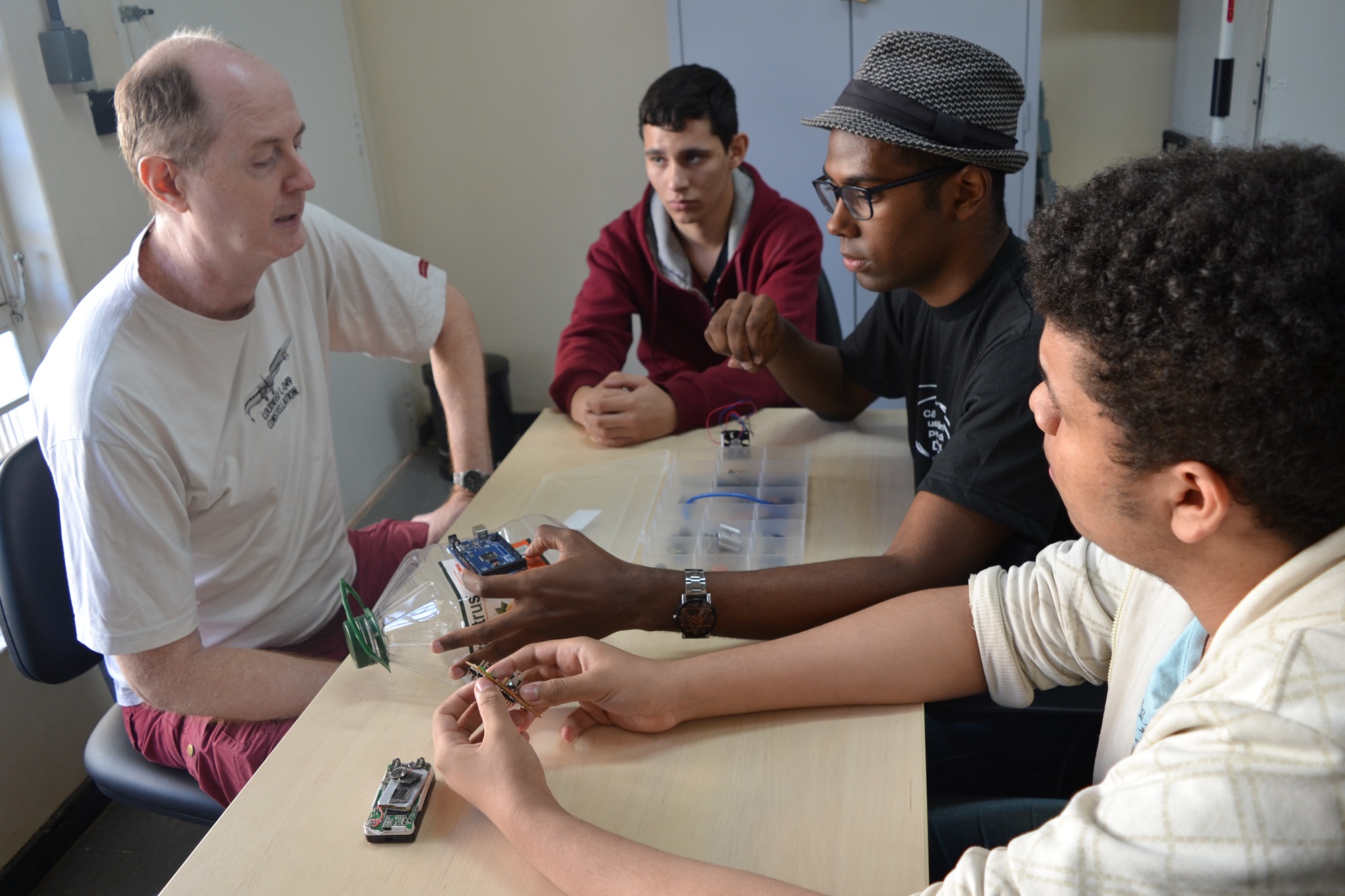 Professor de Química do Câmpus Goiânia do IFG, Fernando Schimidt, que coordena a pesquisa, mais estudantes do curso técnico integrado em Eletrônica (Victor Gabriel, Gabriel de Souza, Danilo Torres) discutem o desenvolvimento do protótipo do nariz eletrônico.